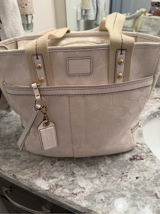 Coach Handbags - COACH Cream and Beige Signature Canvas Tote with Leather Charm